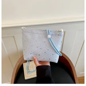 Detailed view of the light blue star print crossbody bag with adjustable drawstring strap.