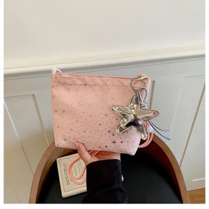 Pink crossbody shoulder bag with silver star prints and shiny star pendant accessory.