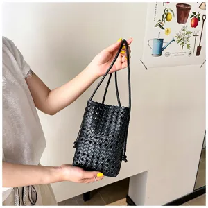 Vue detaillee d'un mini sac seau tresse en cuir souple noir ideal pour l'ete casual.