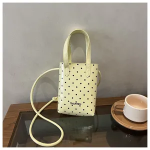 Detalle de mini bolso cruzado de lunares amarillos, escena de bolso de verano lindo.