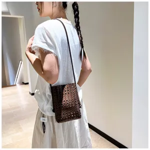Vue détaillée du sac seau bandoulière en cuir tressé décontracté dans un cadre minimaliste.