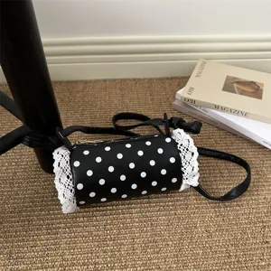 Borsa a tracolla cilindrica a pois neri con bordo in pizzo bianco, stile vintage grazioso e chic.