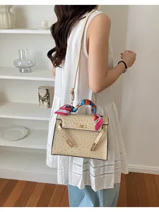 Chic beige ostrich pattern women shoulder handbag with stylish colorful silk scarf accessory.