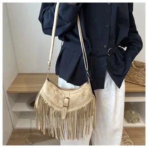 Detail shot of a retro western style suede fringe shoulder bag with adjustable strap for women.