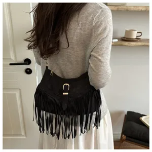 Detailed view of women black suede fringe shoulder bag, western retro style bag with buckle.