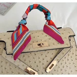 Elegant women top handle shoulder bag with luxury ostrich texture and silk scarf.