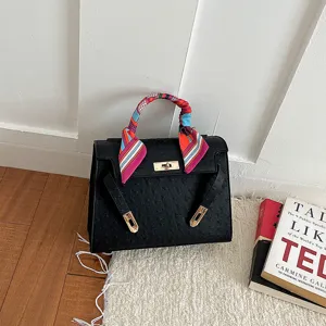 Elegant black structured handbag with ostrich texture and gold hardware for daily fashion wear.