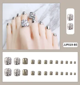 Close-up detail van zilveren metallische en sprankelende strass teennagels, prachtige afwerking.