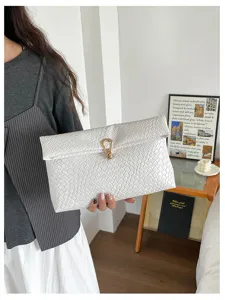 Stijlvolle geweven enveloppe clutch tas voor vrouwen met een minimalistische metalen gesp.