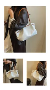 Detailed view of white hobo shoulder bag with brown straps, showing style and capacity.