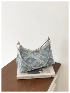 Casual τsάντα ώμου denim με λευκό τύπωμα αστέρι και φθαρμένες άκρες σε ξύλινο τραπέζι προβολής.