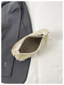 Λεπτομέρεια chic τσάντας ώμου από tweed με εσωτερική φόδρα και κομψά κρόσσια.