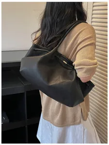 Black leather shoulder bag for women, chic minimalist hobo purse with slouchy design.