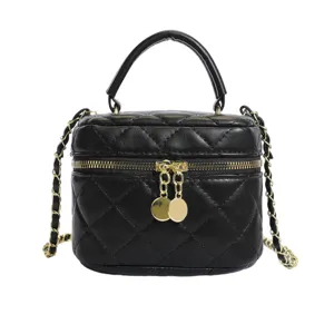 Black quilted top handle crossbody bag with gold chain strap and elegant vanity box design.