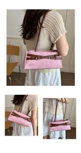 Close-up detail shot of the pink denim shoulder bag featuring stylish brown belt straps.