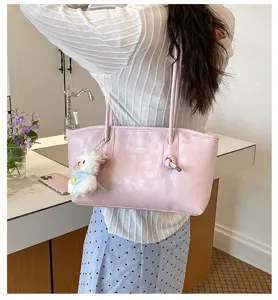 Pink tote shoulder bag detail view with cute plush pendant, casual daily style fashion purse.