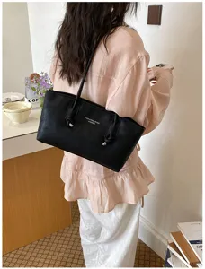 Detail view of the minimalist black shoulder tote bag, stylish daily commuting accessory.