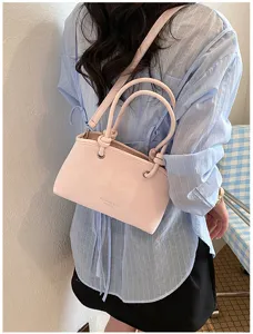 Stilvolle rosafarbene Umhängetasche für Damen mit stylischen Knotengriffen für den Alltag.
