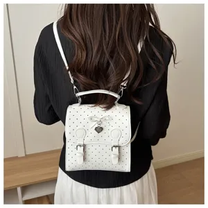 Chic white polka dot mini backpack detail showing cute bow and heart charm, versatile style.