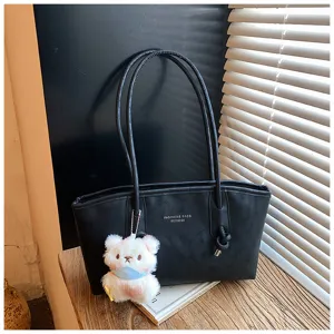 Classic black tote bag detail with cute plush bear pendant, stylish casual daily handbag.