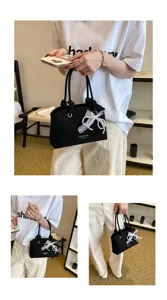 Schwarze Damen Handtasche aus Canvas mit weißer Spitzen Schleife und Perlen im Sommer Design.