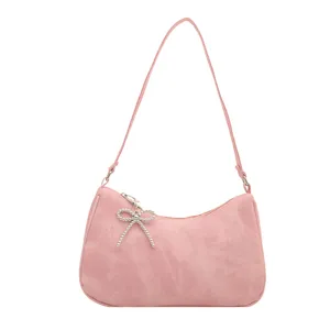 Pink shoulder underarm bag for women with elegant beaded bow pendant, fashion commuting style.