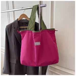 Gedetailleerd overzicht van de kleurrijke opvouwbare shopper aan rek met trekkoord.