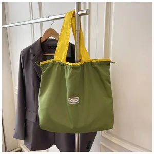 Grote stoffen shopper tas, stijlvol chic groen en geel kleurblok trekkoord ontwerp.