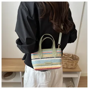 Πολύχρωμη υφαντή ψάθινη τσάντα χιαστί για γυναίκες, λεπτομέρειες μόδας καλοκαιρινών διακοπών.