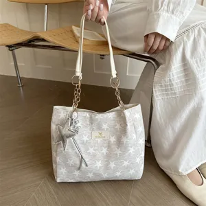 Detailopname van stijlvolle sterrenhandtas met elegante kettingriemen en sterrenbedel.