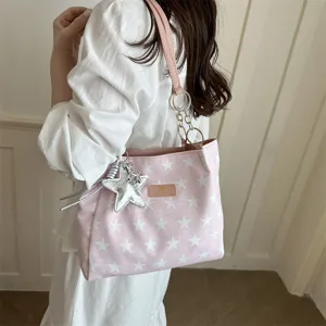 Roze ster print schouder tote tas detailweergave met zilveren star hanger en metalen ringen.