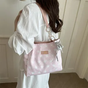 Gedetailleerd uitzicht op de chique roze sterrenprint tote tas met metalen kettingriemen en hanger.