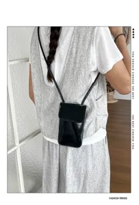 Women black patent leather crossbody phone bag, stylish mini shoulder bag for daily wear.