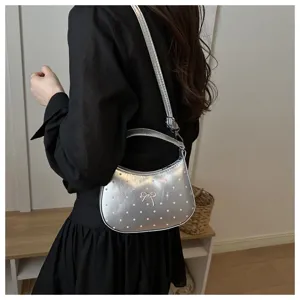 Bolso de hombro luna plateado con lunares y lazo, accesorio elegante para mujer.