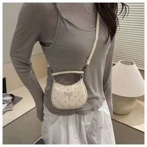 Vista detallada del lindo bolso cruzado mini de lunares con un lazo para mujer.