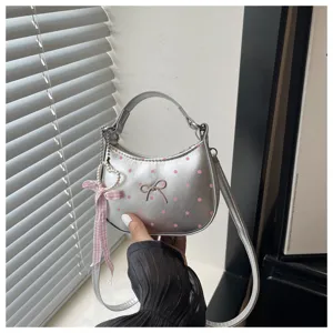 Bolso de hombro plateado de lunares con lazo dulce y colgante de cinta de perlas.