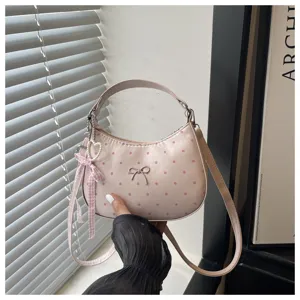 Vista detallada del bolso de hombro luna de lunares rosa dulce con lazo lindo y colgante.