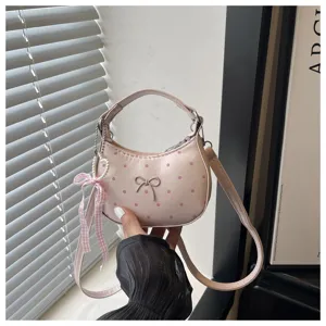 Bonito bolso de hombro rosa de lunares con lazo y colgante de cinta de perlas.