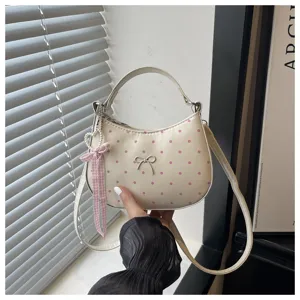 Bolso cruzado de media luna de lunares dulces con lindo lazo y dije de cinta.