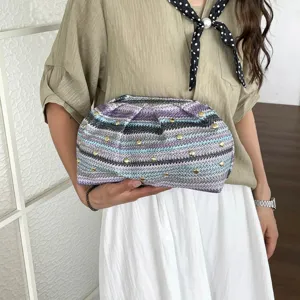 Pochette tissée à la main avec rayures colorées et clous dorés pour plage et style.