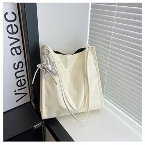 Detail view of the elegant patent leather tote bag featuring a glossy finish and silver star charm.