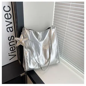 Silver patent leather tote bag detail, featuring double shoulder straps and a chic star charm.