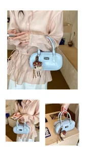 Détails du sac à main bleu clair avec charmant pendentif d'ours et détail en métal.