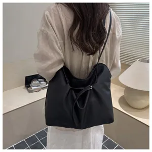 Detailed view of the black slouchy shoulder bag showing soft leather texture and stylish buckle.