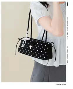 Detail view of the cute polka dot shoulder bag with lace bow and charming pendant design.
