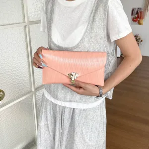 Detail shot of a stylish pink pleated envelope clutch bag with metal clasp for daily commuting.