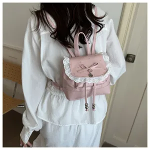 Zaino rosa floreale con finiture in pizzo, fiocco e ciondolo per stile casual quotidiano.