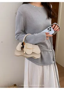 bolso de mano chic minimalista de ante beige con abalorios de madera y detalle metálico
