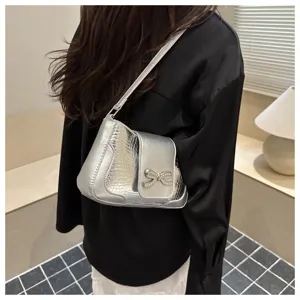Bolso de hombro plateado metalizado con elegante lazo de diamantes y patrón de cocodrilo.
