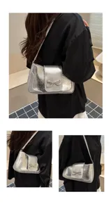 Bolso de hombro metalizado plateado con lazo de diamantes brillantes y textura cocodrilo.